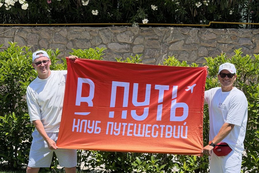 Двое участников команды держат флаг клуба «В ПУТЬ»